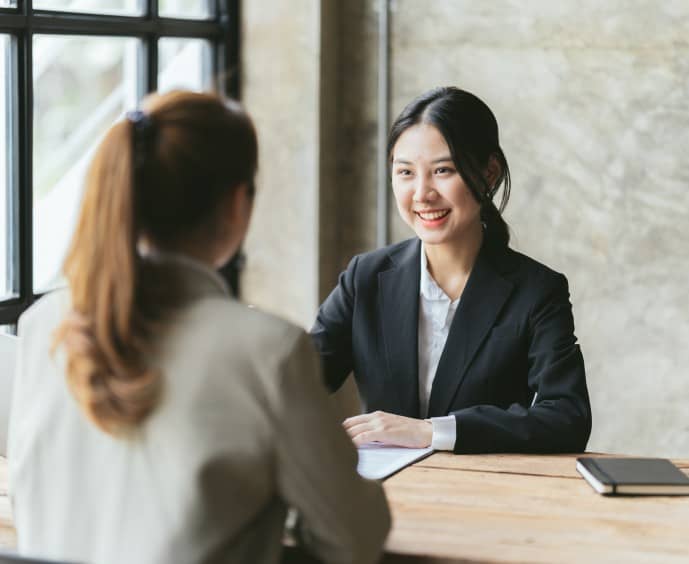 Professional business meeting between two women in an office setting