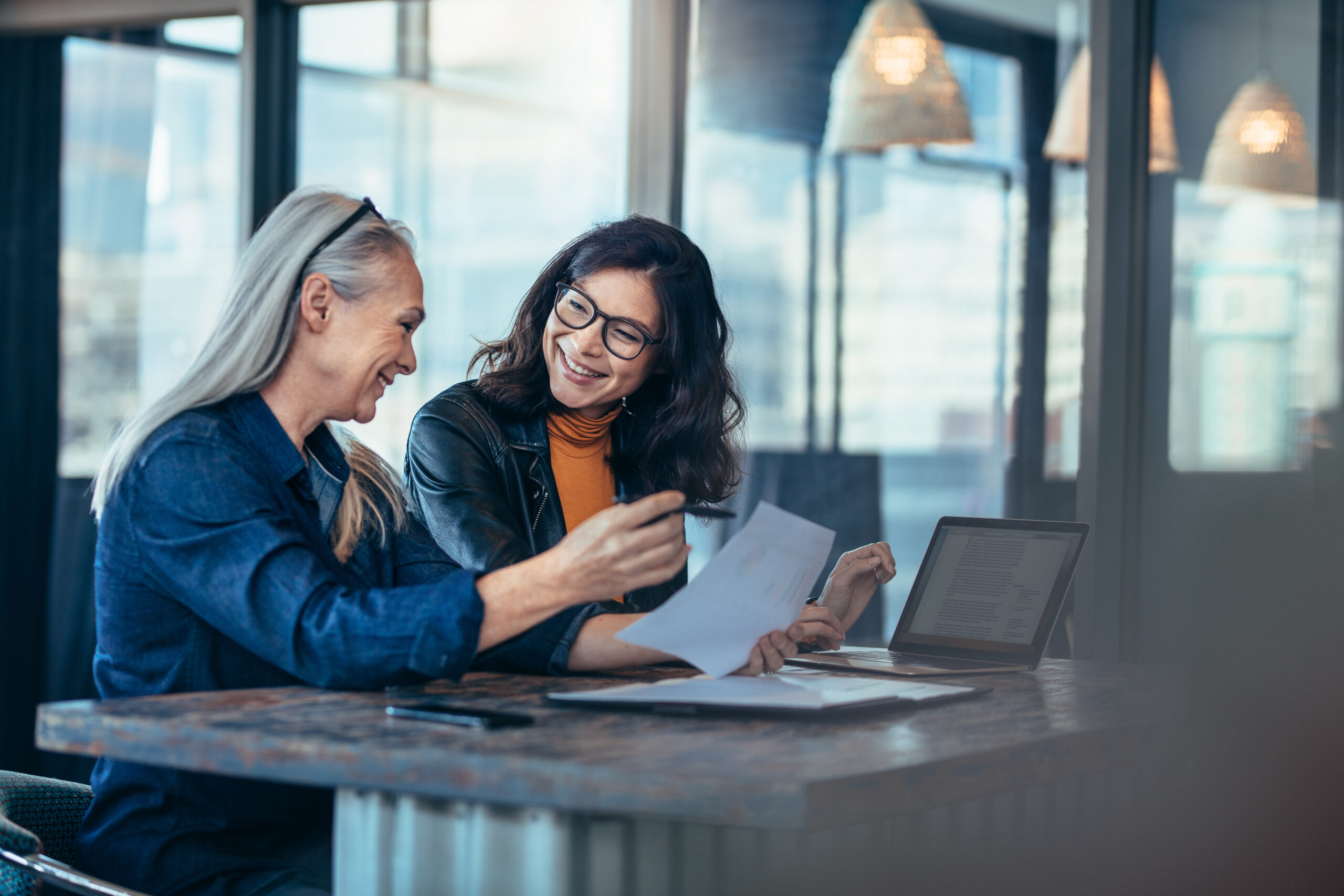 Two professionals discussing documents as part of discretionary portfolio management services.